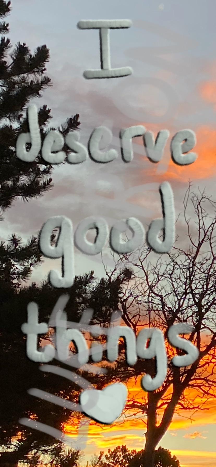 A colorful sunset with shades of orange and pink is visible behind silhouetted trees. The text "I deserve good things" is prominently displayed over the image, accompanied by a small heart graphic.